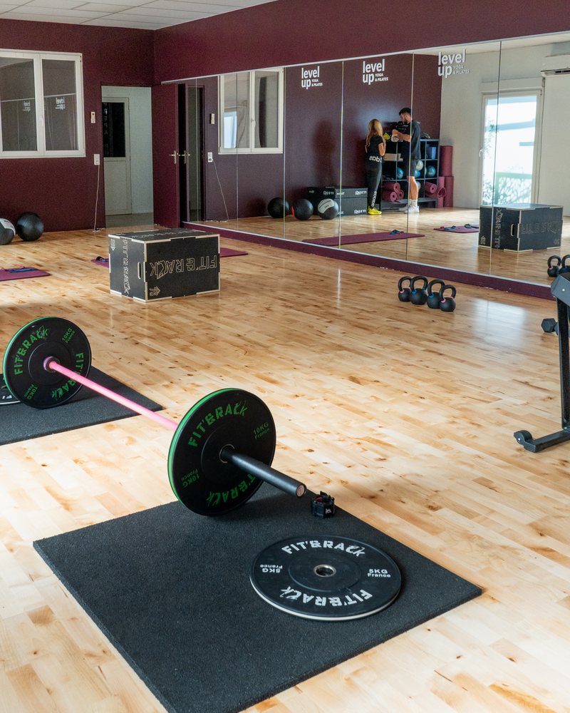 Salle d’entraînement avec miroirs, barres et kettlebells