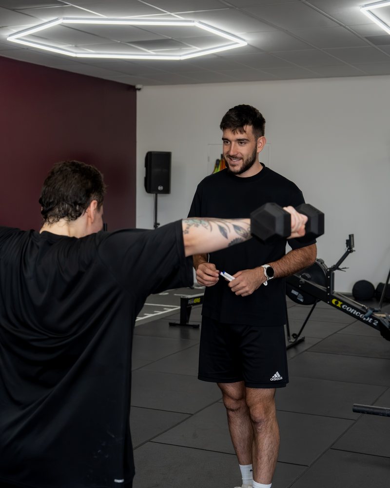 Exercice avec haltère guidé par le coach